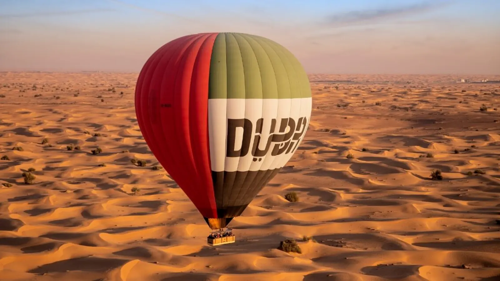 Hot air balloon over Dubai desert at sunrise